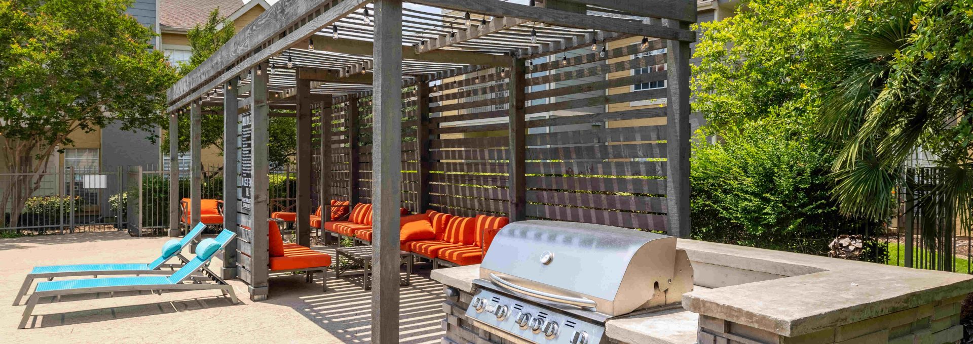 a patio with a grill and seating area at The Westmount at Three Fountains