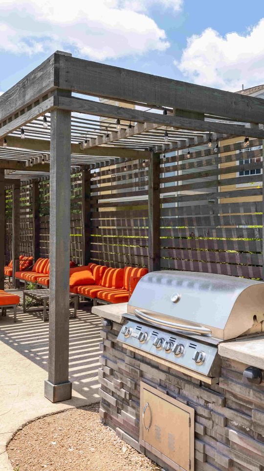 a patio with a grill and seating area at The Westmount at Three Fountains